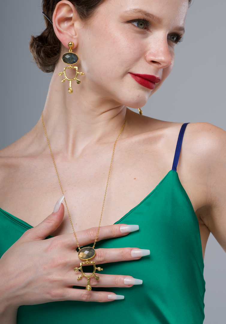 Ra Necklace in 24k gold plate with matching earrings on model in green dress.
