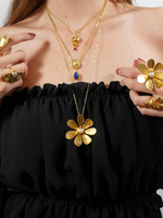 Load image into Gallery viewer, Gold flower necklace with matching rings, layered with two other necklaces.