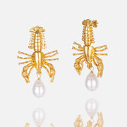 Gold crab-shaped earrings with pearl detail.