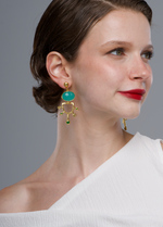 Load image into Gallery viewer, Baroque Earrings in 24k gold plate with green accents on model.
