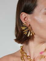 Load image into Gallery viewer, Hand-set 24k gold-plated leaf earrings on a model.
